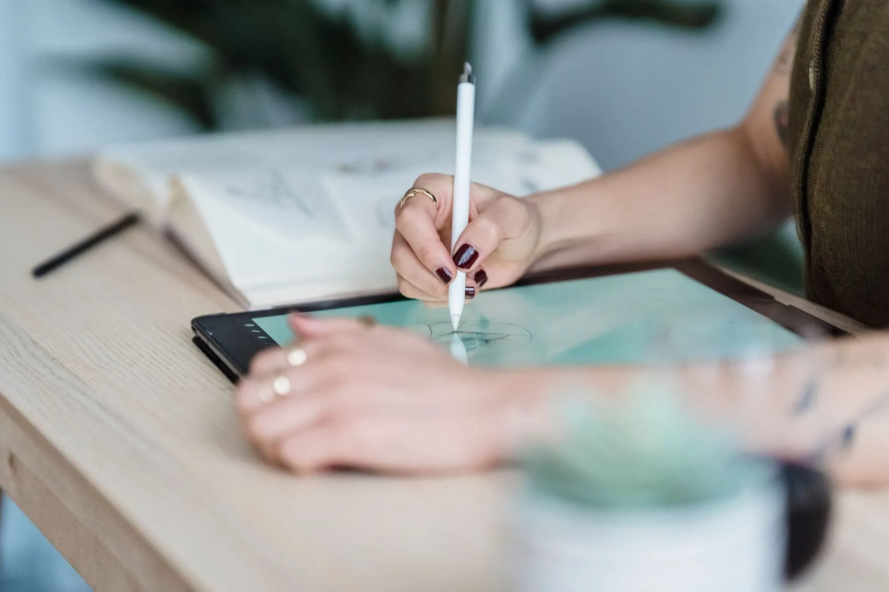Mãos de designer desenhando com caneta em uma mesa digitalizadora