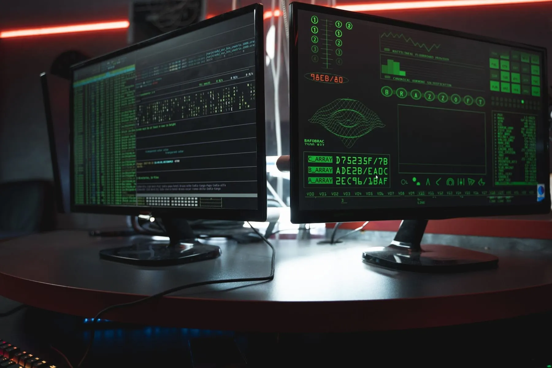 Dois monitores com código e registros de sistema